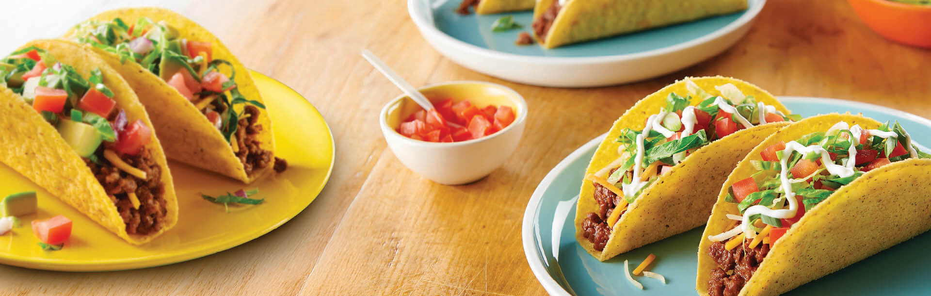 tacos di manzo conditi con panna e coriandolo serviti su piatti con salsa di pomodoro